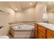 Bathroom featuring a corner tub, tile accents, and wood vanity with sink at 250 Upper Forest Rd, Idaho Springs, CO 80452