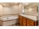 Bathroom featuring a corner tub, tile accents, and wood vanity with sink at 250 Upper Forest Rd, Idaho Springs, CO 80452