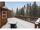 The wooden deck offers a snow-covered space with a wooded, private view at 250 Upper Forest Rd, Idaho Springs, CO 80452