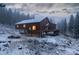 Exterior view of a snow-covered home, surrounded by trees and greenery at 250 Upper Forest Rd, Idaho Springs, CO 80452