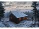 An exterior view of a snow-covered home on a foggy day, surrounded by trees at 250 Upper Forest Rd, Idaho Springs, CO 80452