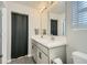 Modern bathroom with double vanity, white countertops, and stylish black and white floor tiles at 529 Beckwourth, Fort Lupton, CO 80621