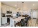 Well-lit open floor plan combining kitchen with island seating and dining area with chandelier at 529 Beckwourth, Fort Lupton, CO 80621