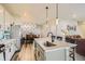 A well-lit kitchen featuring a large island with a sink and an open layout that connects to the living and dining areas at 529 Beckwourth, Fort Lupton, CO 80621