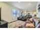 Cozy living room featuring a comfortable leather sofa, large windows, and seamless kitchen access at 529 Beckwourth, Fort Lupton, CO 80621