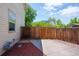 Concrete patio with wood fencing, gravel, and a gas meter on the side of the home at 4571 S Memphis St, Aurora, CO 80015