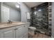Modern bathroom featuring a glass enclosed shower with pebble floor and neutral vanity at 4571 S Memphis St, Aurora, CO 80015