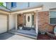 Close-up of the front entrance featuring a welcoming door, brick accents, and decorative plants at 4571 S Memphis St, Aurora, CO 80015