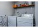 Laundry area with modern white washer and dryer and storage shelf at 4571 S Memphis St, Aurora, CO 80015