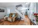 Cozy living room featuring hardwood flooring, a staircase, and a view of the front door at 4571 S Memphis St, Aurora, CO 80015