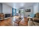 Bright and airy living room with a brick fireplace, wood floors, and comfortable seating at 4571 S Memphis St, Aurora, CO 80015