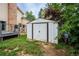 Backyard shed with a metal door, gray exterior, and lawn with new growth at 4571 S Memphis St, Aurora, CO 80015