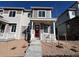 Charming townhome featuring stone accents, a red front door, and a cozy porch perfect for enjoying the neighborhood views at 6618 N Nepal Ct, Aurora, CO 80019