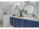 Bathroom showcasing dual sinks with large mirrors, stylish blue vanity, and modern fixtures at 6283 Kilmer Loop # 201, Golden, CO 80403