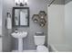 Stylish bathroom featuring a pedestal sink, modern fixtures, hexagon shelves, and a shower-tub combo at 6283 Kilmer Loop # 201, Golden, CO 80403