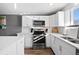 Modern white kitchen with stainless steel appliances at 12555 W 61St Ave, Arvada, CO 80004