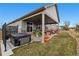 Exterior view of a home featuring a hot tub and covered patio with outdoor seating at 23600 E Swallow Cir, Aurora, CO 80016