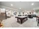 Large finished basement featuring a pool table, multiple seating areas, and a staircase at 23600 E Swallow Cir, Aurora, CO 80016