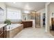 Bright bathroom with a soaking tub, walk-in shower, double vanity, and separate toilet room at 23600 E Swallow Cir, Aurora, CO 80016