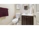 Powder room featuring a white toilet, an oval mirror, and a dark wood vanity at 23600 E Swallow Cir, Aurora, CO 80016