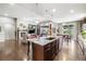Open-concept kitchen with granite island, stainless steel appliances, and adjacent living area with fireplace at 23600 E Swallow Cir, Aurora, CO 80016