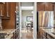 Galley kitchen with stainless steel refrigerator and oven, and dark wood cabinets at 23600 E Swallow Cir, Aurora, CO 80016