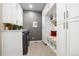 Well-organized laundry room featuring white cabinets, built-in bench, and gray walls at 23600 E Swallow Cir, Aurora, CO 80016