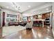 Spacious living room connected to the kitchen with hardwood floors, large windows, and comfortable seating at 23600 E Swallow Cir, Aurora, CO 80016