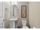 Charming powder room featuring a pedestal sink, toilet, and decorative artwork at 23600 E Swallow Cir, Aurora, CO 80016