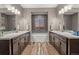 Bathroom featuring double sinks, soaker tub, gray walls, tile floors and two vanities at 14845 Haley Ave, Parker, CO 80134