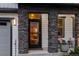 Inviting front porch with stone columns, seating, and a view into the cozy interior at 14845 Haley Ave, Parker, CO 80134