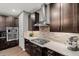 Close-up of kitchen featuring stainless steel range hood, gas stovetop, decorative backsplash, and granite countertops at 14845 Haley Ave, Parker, CO 80134