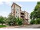 Multi-story condo building showcasing brick accents, balconies, and mature trees at 1780 N Washington St # 305, Denver, CO 80203