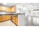 Bright kitchen featuring stainless steel appliances and light wood cabinets, seamlessly opening to a spacious living area at 1780 N Washington St # 305, Denver, CO 80203