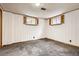 Cozy basement area with plush carpeting, wood detail, and natural light from shuttered windows at 2710 Zenobia St, Denver, CO 80212