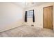 Carpeted bedroom featuring a window with dark curtains and a light-colored door at 2710 Zenobia St, Denver, CO 80212