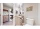 Small bathroom with a stacked washer/dryer, modern vanity, and light wood-look flooring at 463 Locust St, Denver, CO 80220