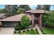 Stunning brick home with a tile roof, lush landscaping, and a modern garage door at 463 Locust St, Denver, CO 80220