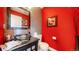 Stylish powder room with a glass bowl sink and red accent wall at 463 Locust St, Denver, CO 80220