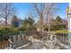 Serene back deck with outdoor seating, offering a tranquil view of lush landscaping and mature trees at 11989 E Lake Cir, Greenwood Village, CO 80111