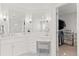 Bright bathroom vanity featuring double mirrors and lights adjacent to a walk-in closet at 11989 E Lake Cir, Greenwood Village, CO 80111