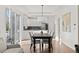 Bright dining room with wood floors, modern light fixture, and open access to a stylish kitchen with stainless steel appliances at 11989 E Lake Cir, Greenwood Village, CO 80111