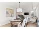 Open dining space featuring a modern light fixture, a wooden table, and comfortable seating, all complemented by a stylish art piece at 11989 E Lake Cir, Greenwood Village, CO 80111