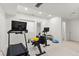 Basement gym featuring modern treadmill and rowing machines, dumbbells and ample lighting at 11989 E Lake Cir, Greenwood Village, CO 80111