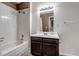 Traditional bathroom featuring a shower-tub combo, dark wood vanity, and a framed mirror at 4194 S Fraser Way # B, Aurora, CO 80014