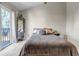 Well-lit bedroom featuring a queen bed, mirrored wall decor, and access to the balcony at 4194 S Fraser Way # B, Aurora, CO 80014