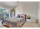 Well-lit bedroom featuring a queen bed, mirrored wall decor, and access to the balcony at 4194 S Fraser Way # B, Aurora, CO 80014