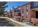 Brick condo units showcase charming front patios and balconies with beautiful landscaping and walkways at 4194 S Fraser Way # B, Aurora, CO 80014