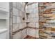 Modern tiled walk-in shower featuring a handheld shower head and a stone accent wall at 4194 S Fraser Way # B, Aurora, CO 80014