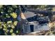 Aerial view of modern home with sleek lines and a dark roof, circular drive and surrounded by lush trees at 13415 S Resort Dr, Conifer, CO 80433